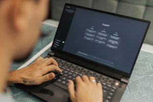 Person typing on a laptop with the ChatGPT interface open, illustrating how ChatGPT is used for AISEO workflows and content optimisation.