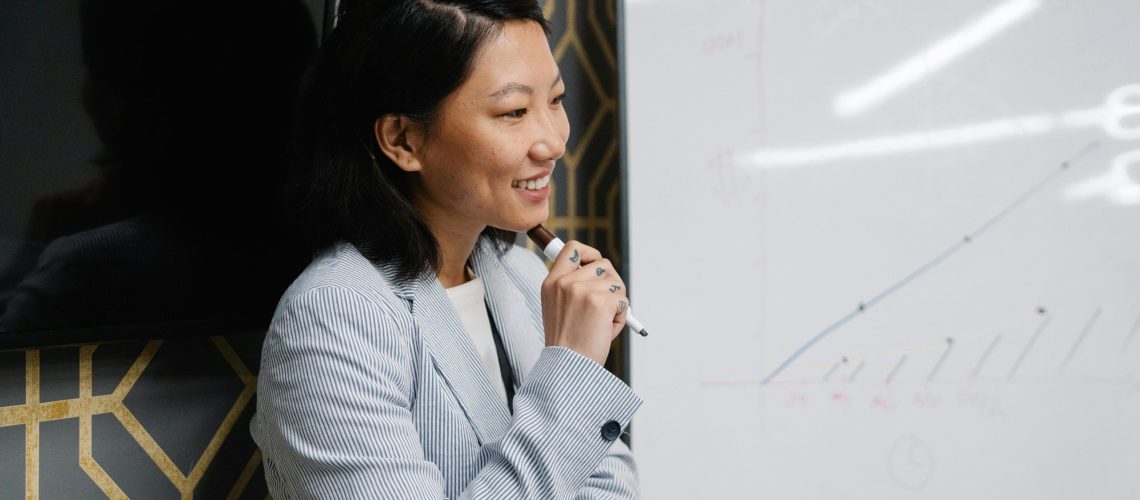 A professional from a digital marketing agency in Singapore presenting campaign performance trends on a whiteboard.