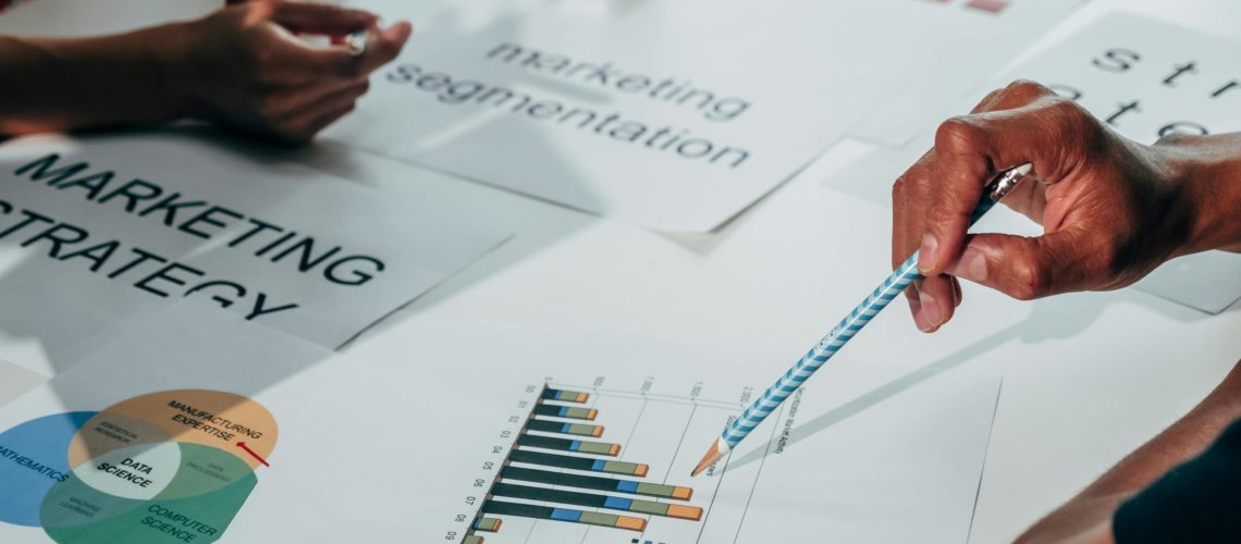 Team members reviewing marketing and SEO strategy documents, analysing charts and graphs during a planning discussion.