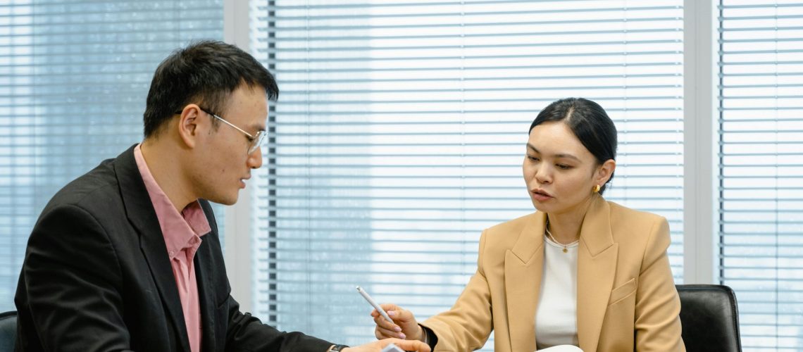 Two business professionals discussing B2B marketing strategies during a meeting in a modern office.